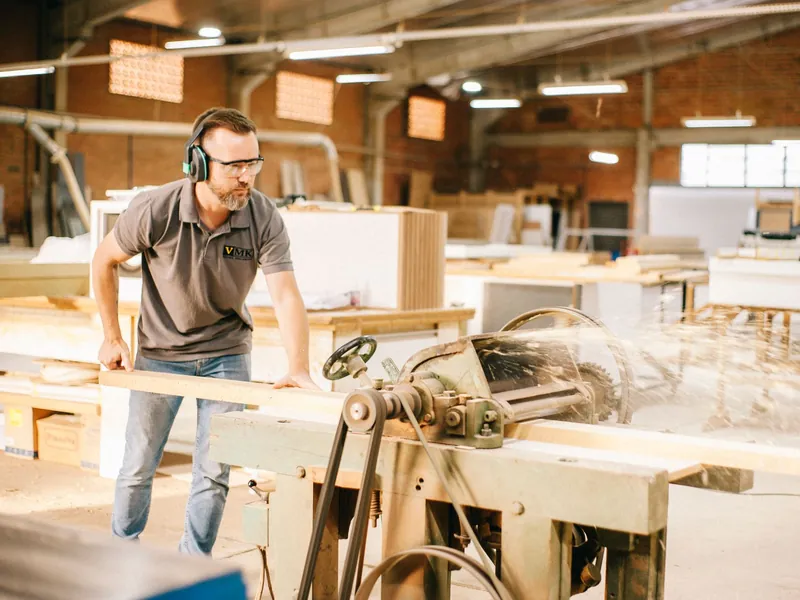 A carpenter working at a bench in his workshop.